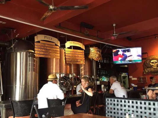 A couple sit at a table inside the brew pub. 