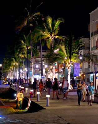 People walking on the malecon at night in Puerto Vallarta Mexico. 