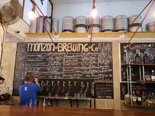 Bartender pouring a pint of ale from a row of taps.