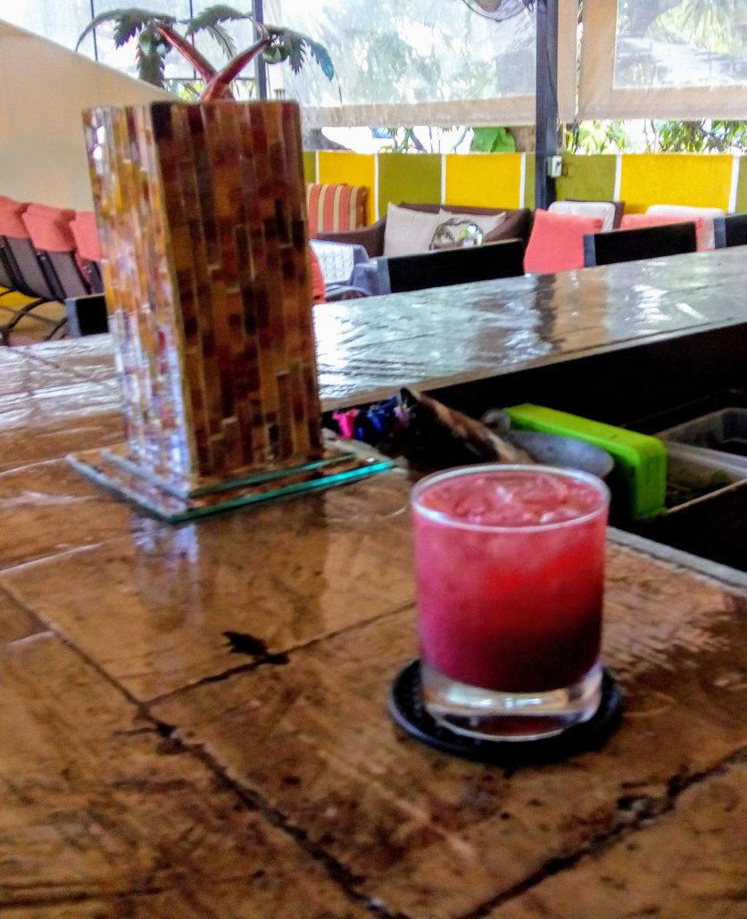 a colorful blackberry cocktail on the bar of the twisted palms bar. 