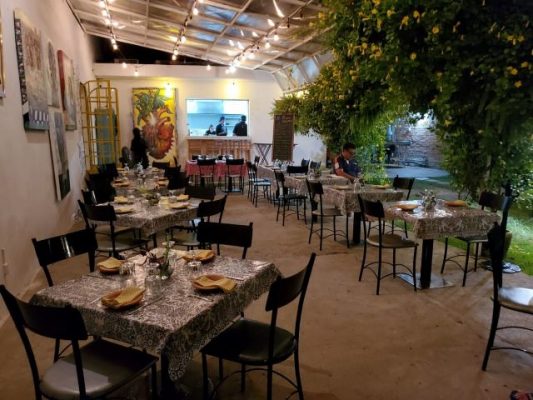 Tables on a garden patio in restaurant Barrio bistro in Puerto Vallarta