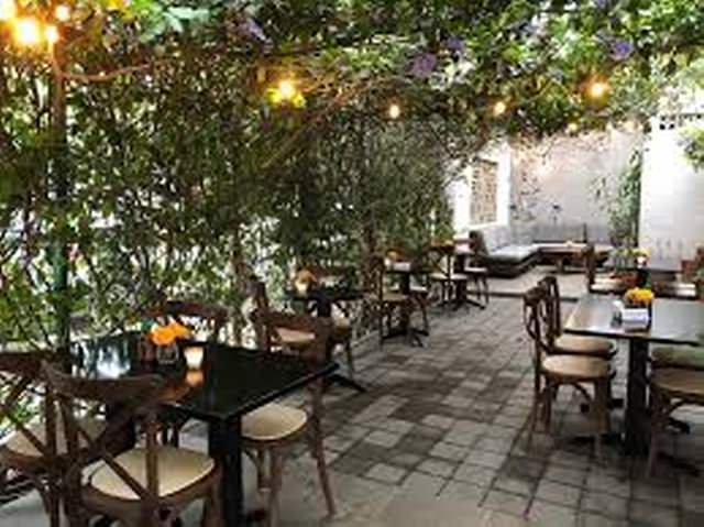 Tables on a garden patio in restaurant Bonito Kitchen in Puerto Vallarta