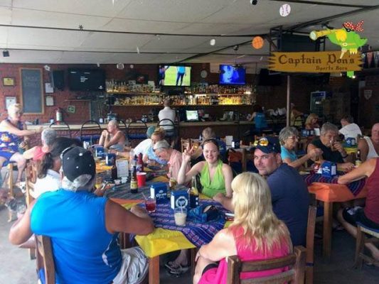 patrons gathered
around  tables in
Captain Don's bar in Puerto-Vallarta.