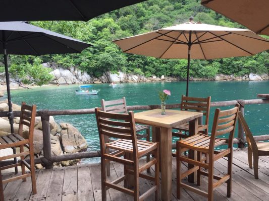 Tables on a deck overlooking a bay at restaurant Ocean Grill in Puerto Vallarta. 