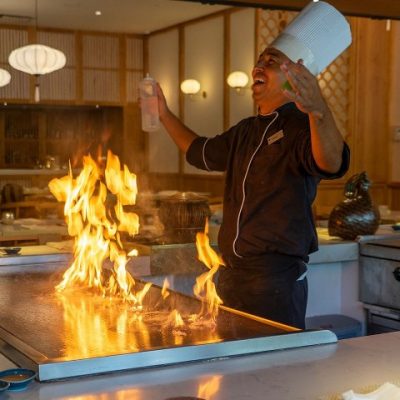 chef celebrates over a flaming grill