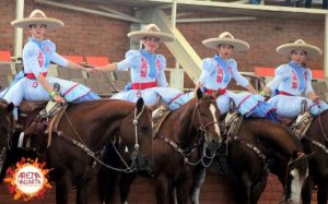 mexican women on horses in charro attire.