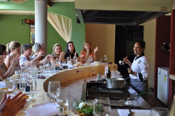 Chef Miriam Flores teaching a class of students in her kitchen.