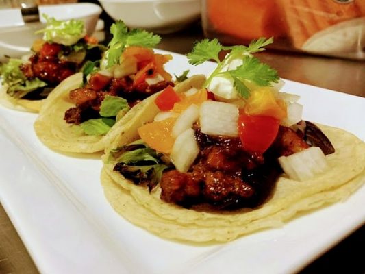 Three tacos of oxtail on a plate.