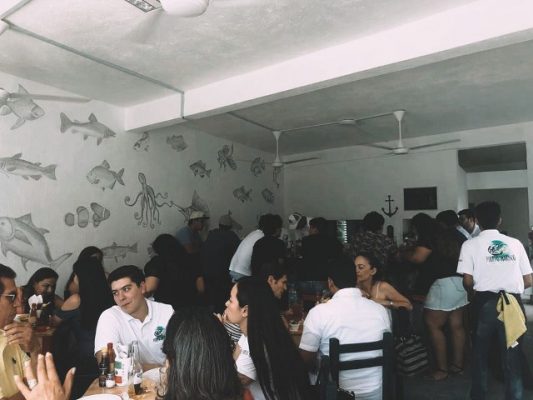 people gathered round tables in restaurant puerto marisco in puerto vallarta.