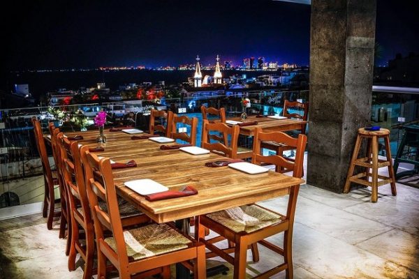 dining table with a nighttime view of church steeples and the skyline of Puerto Vallarta