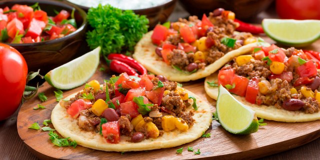 three mexican tacos with limes