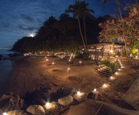 candel lit tables along a beach in the mexican jungle