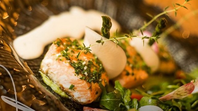 a filet of salmon with herbs and a white sauce