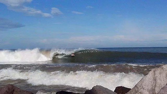 A surfer on a bif wave in the Bay of Banderas, Mexico. 