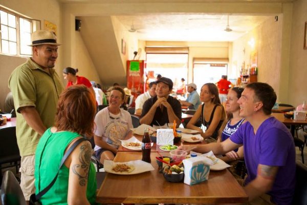 A food tour guide, from Vallarta Food ours,  explains Mexican Cuisine to tourists in Puerto Vallarta. 