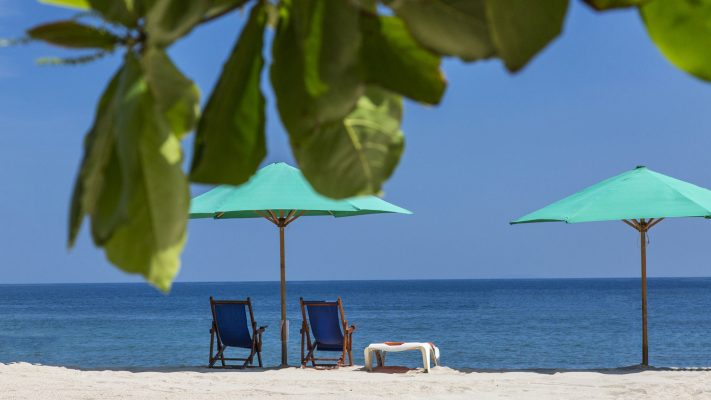 beach chairs and colorful parasols on the shore of the Bay of Banderas in Puerto Vallarta Mexico